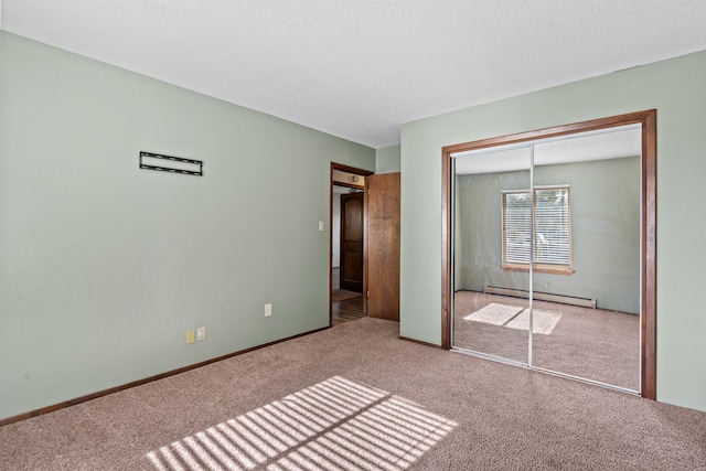 unfurnished bedroom with carpet flooring, a baseboard heating unit, and a closet