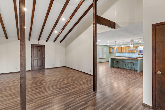 unfurnished living room with beamed ceiling, a baseboard radiator, high vaulted ceiling, and dark wood-type flooring