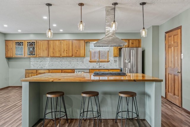 kitchen featuring hardwood / wood-style floors, hanging light fixtures, stainless steel appliances, and a breakfast bar area