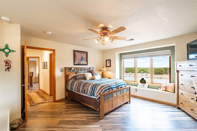 bedroom with hardwood / wood-style flooring, a textured ceiling, and ceiling fan