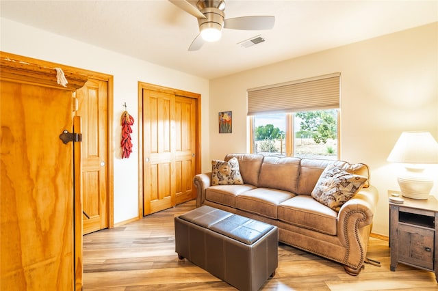 living room featuring light hardwood / wood-style flooring and ceiling fan