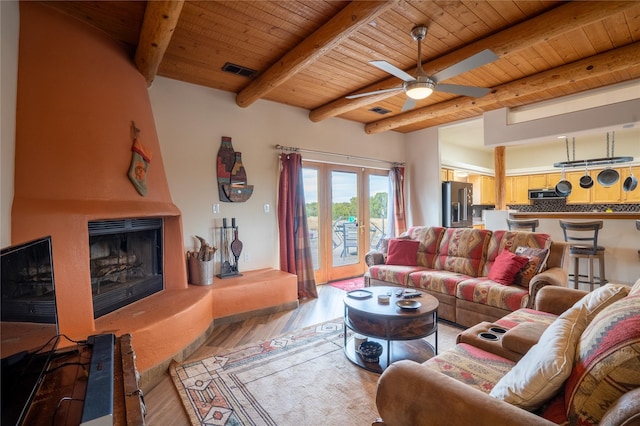 living room with wood ceiling, a large fireplace, wood-type flooring, and beamed ceiling