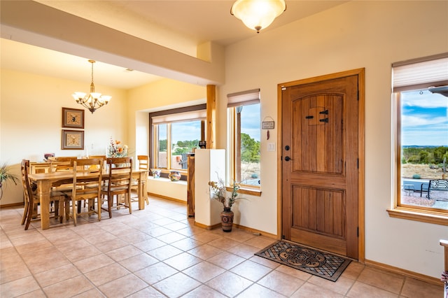 entryway with light tile patterned flooring and a chandelier