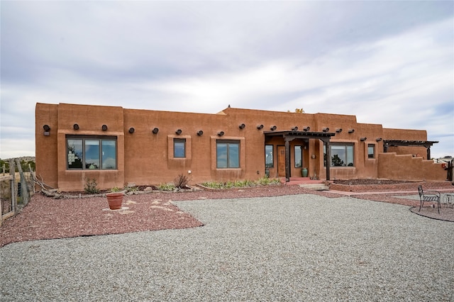 pueblo-style house featuring a patio