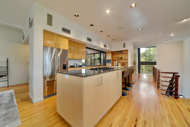 kitchen featuring light wood-type flooring, appliances with stainless steel finishes, and a center island