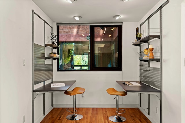 bar with tasteful backsplash, hardwood / wood-style floors, and white cabinets