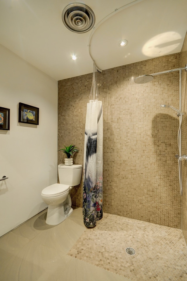 bathroom with tile patterned floors, toilet, and a shower with curtain