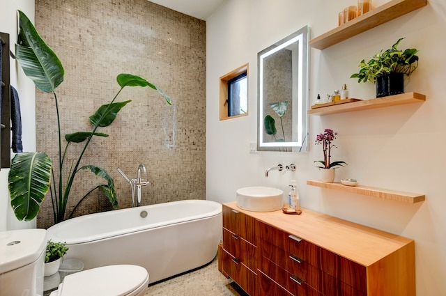 bathroom featuring tile walls, a tub, vanity, and toilet