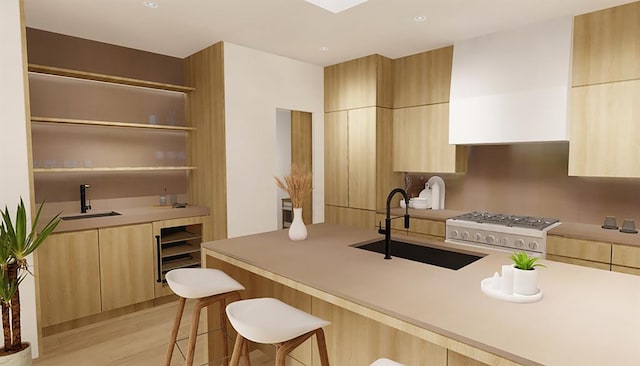 kitchen with white range oven, light wood-type flooring, sink, and a kitchen bar