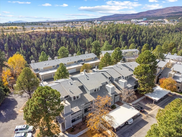 birds eye view of property featuring a wooded view, a mountain view, and a residential view