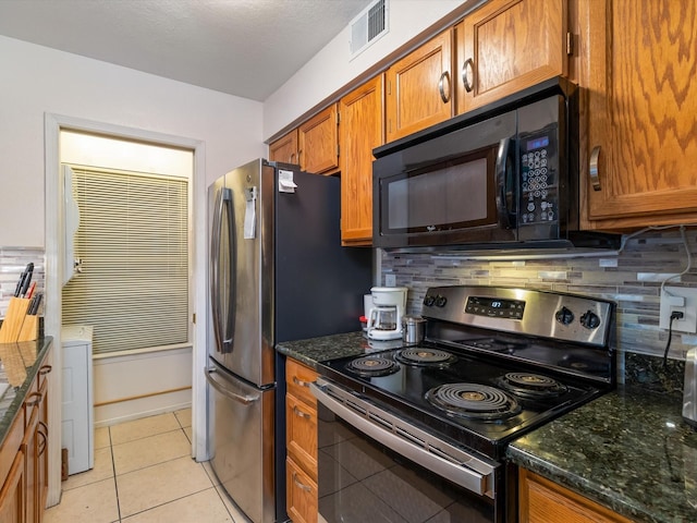 kitchen with light tile patterned floors, visible vents, stainless steel appliances, and decorative backsplash