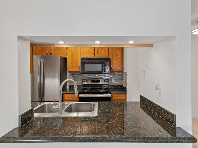 505 Oppenheimer Dr Unit 511, Los Alamos, NM 87544 - kitchen with appliances with stainless steel finishes, a sink, brown cabinets, tasteful backsplash, and dark stone counters
