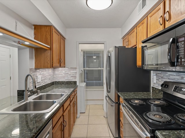505 Oppenheimer Dr Unit 511, Los Alamos, NM 87544 - kitchen with stainless steel appliances, a sink, brown cabinetry, decorative backsplash, and a textured ceiling