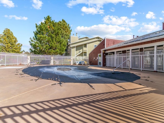 view of swimming pool with a patio and fence