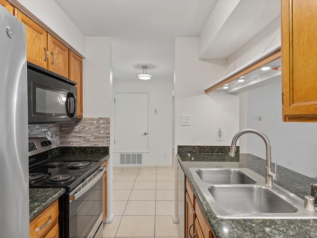 505 Oppenheimer Dr Unit 511, Los Alamos, NM 87544 - kitchen featuring stainless steel appliances, a sink, brown cabinetry, light tile patterned floors, and decorative backsplash