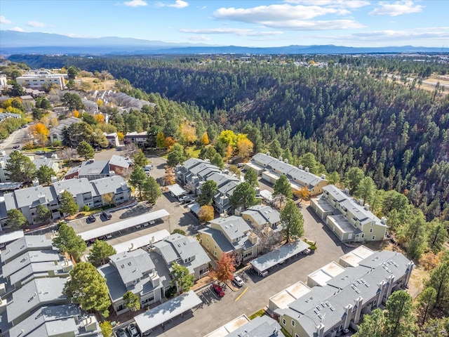 birds eye view of property featuring a mountain view, a view of trees, and a residential view