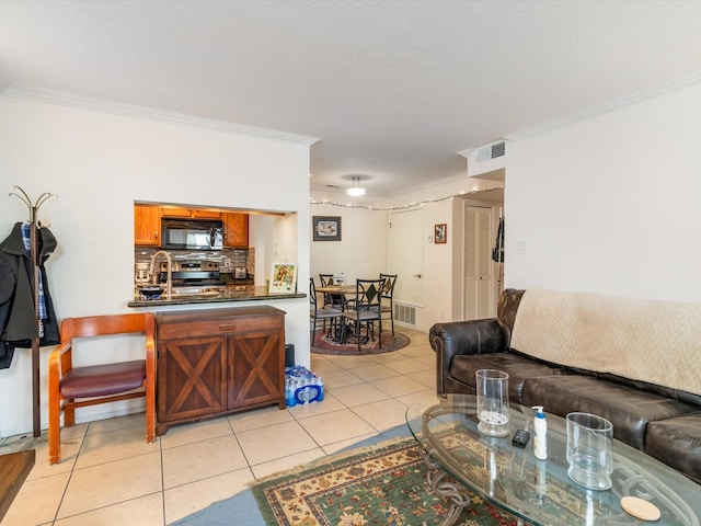 living area featuring light tile patterned floors, visible vents, and ornamental molding