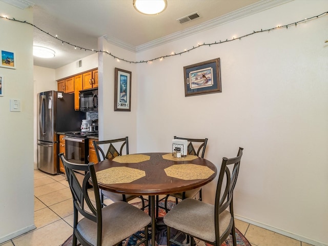 dining room featuring crown molding, light tile patterned floors, baseboards, and visible vents