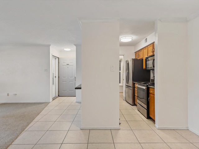 505 Oppenheimer Dr Unit 511, Los Alamos, NM 87544 - kitchen featuring stainless steel appliances, brown cabinets, light tile patterned floors, dark countertops, and ornamental molding