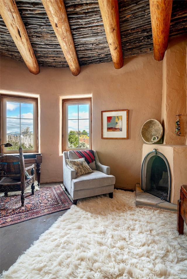 living room with beamed ceiling and concrete floors