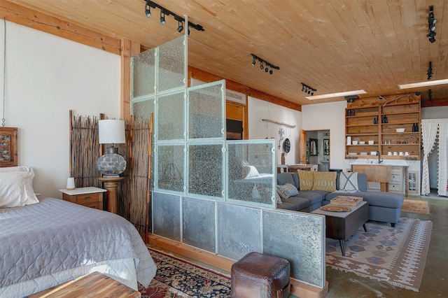 bedroom featuring concrete flooring, rail lighting, and wooden ceiling