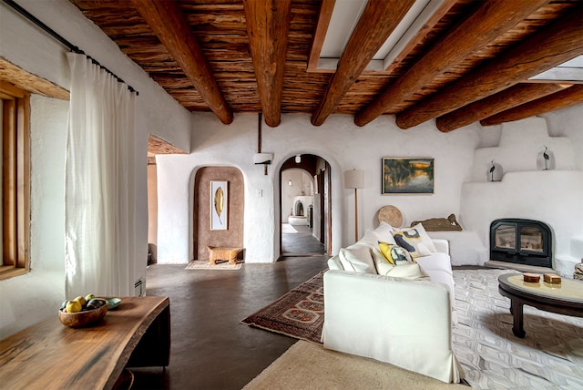 living room featuring beamed ceiling and concrete flooring