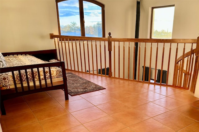 bedroom with multiple windows and tile patterned flooring