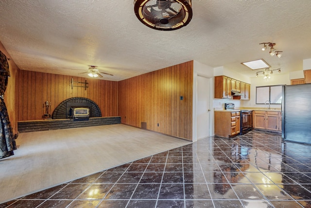 2709 Paseo De Tularosa, Santa Fe, NM 87505 - unfurnished living room featuring a textured ceiling, wood walls, sink, dark wood-type flooring, and ceiling fan