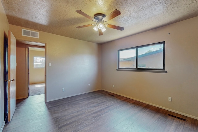 2709 Paseo De Tularosa, Santa Fe, NM 87505 - empty room with a wealth of natural light, a textured ceiling, and dark hardwood / wood-style flooring