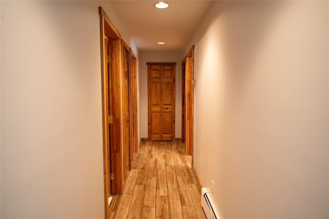 hallway with light hardwood / wood-style floors and a baseboard radiator