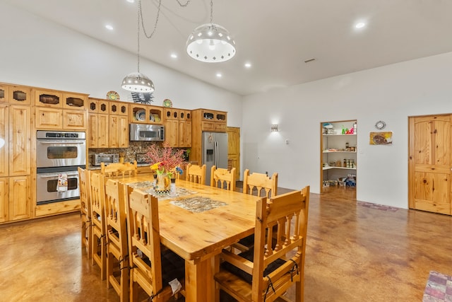 dining area featuring high vaulted ceiling