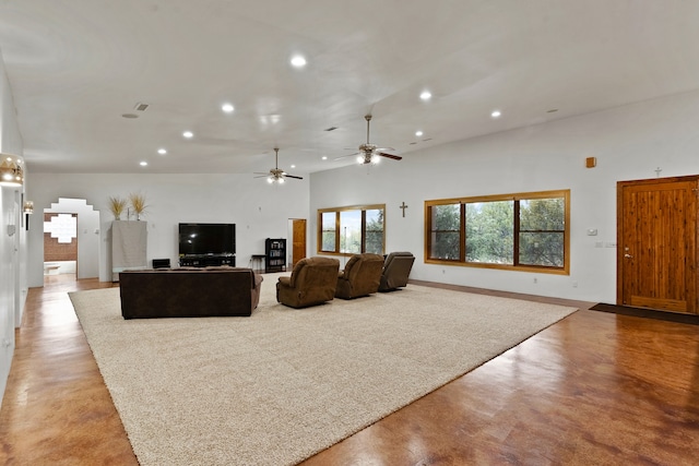 living room featuring ceiling fan and a towering ceiling