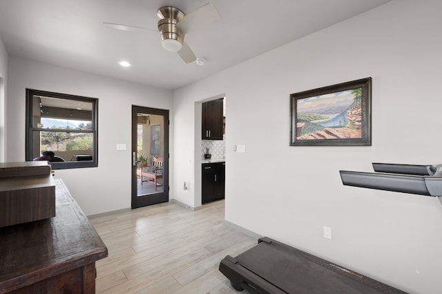 workout area with ceiling fan and light hardwood / wood-style floors