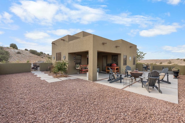 rear view of property featuring an outdoor fire pit and a patio