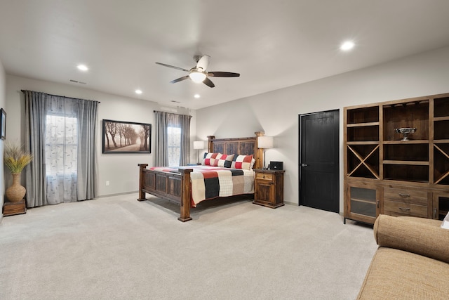 bedroom featuring light colored carpet, multiple windows, and ceiling fan