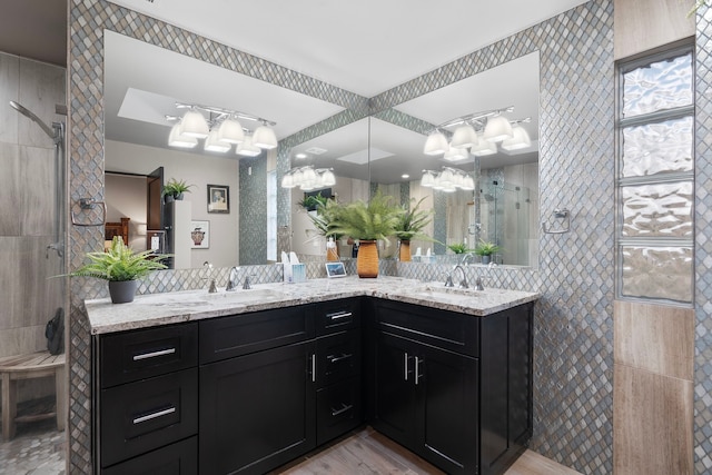 bathroom with tile walls, vanity, wood-type flooring, and a tile shower