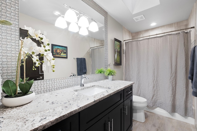 bathroom featuring toilet, vanity, and wood-type flooring