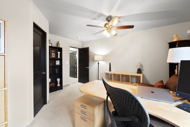 carpeted home office featuring ceiling fan