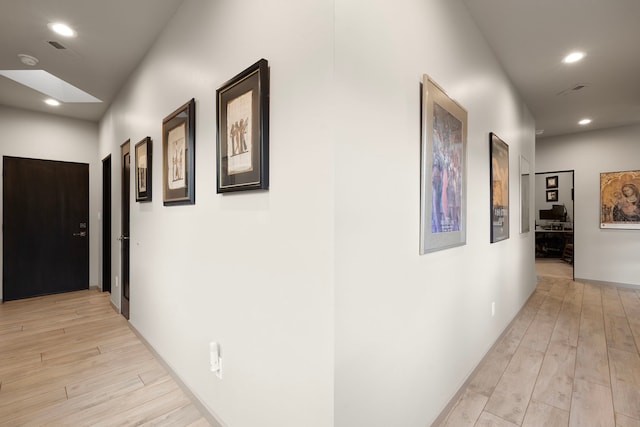 corridor with light hardwood / wood-style floors