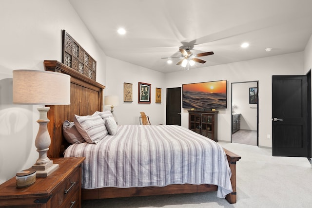 bedroom with light carpet, ceiling fan, and connected bathroom