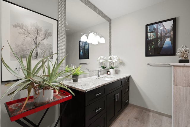 bathroom featuring vanity, an inviting chandelier, and hardwood / wood-style flooring