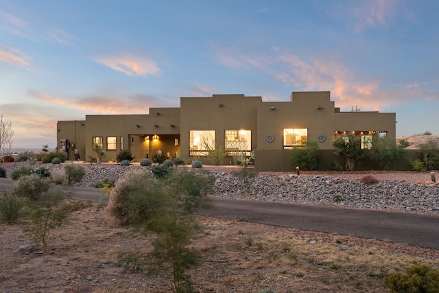 view of back house at dusk