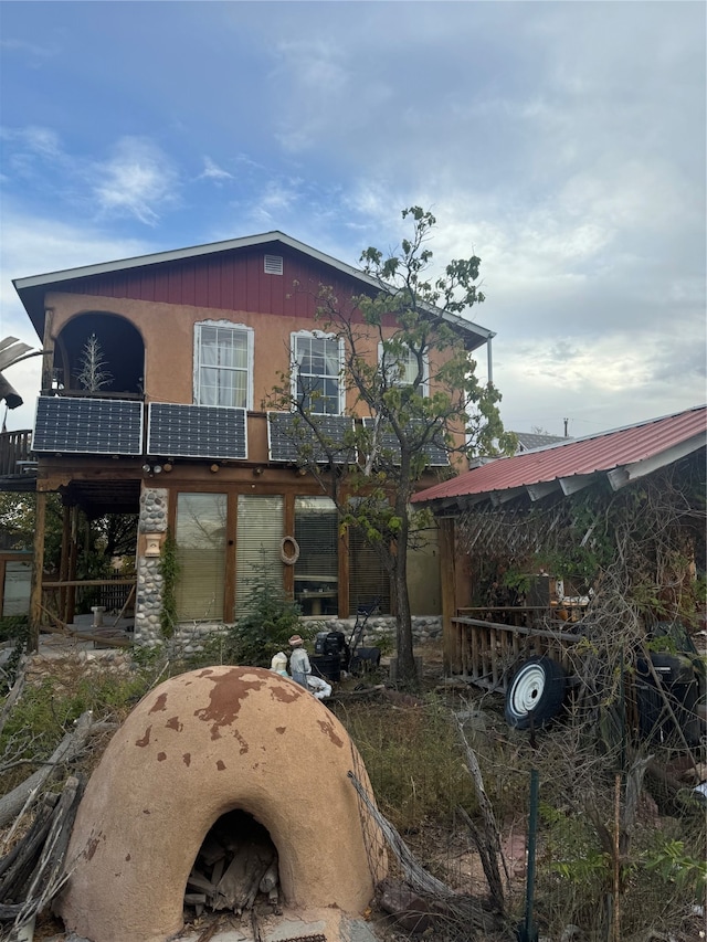 rear view of property featuring solar panels