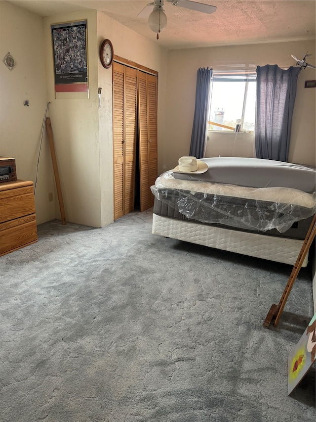 bedroom with a closet, carpet, a textured ceiling, and ceiling fan