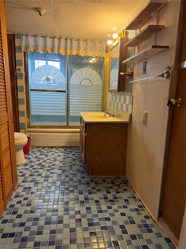 bathroom with walk in shower, vanity, toilet, and a textured ceiling