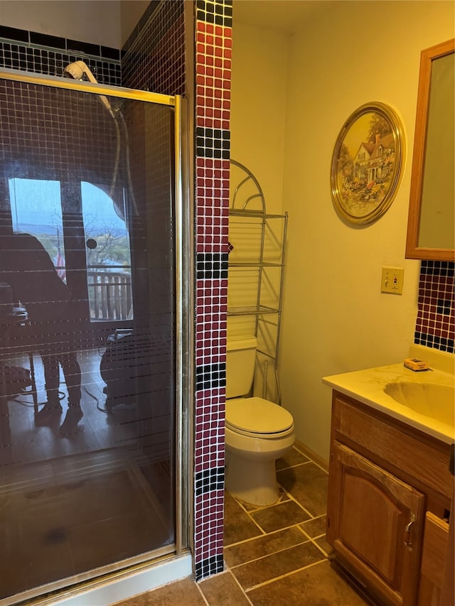 bathroom featuring vanity, tile patterned flooring, toilet, and an enclosed shower