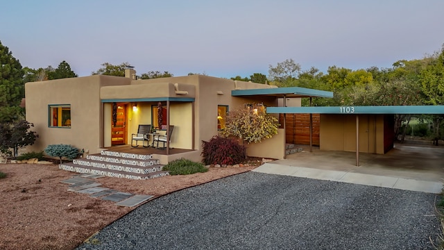 back of property featuring covered porch and a carport