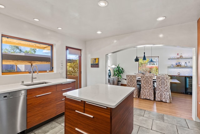 kitchen with sink, pendant lighting, dishwasher, a center island, and plenty of natural light