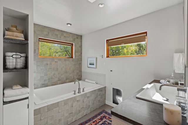 bathroom with tile patterned flooring, plenty of natural light, and a relaxing tiled tub