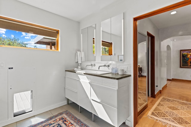 bathroom featuring recessed lighting, baseboards, wood finished floors, and vanity